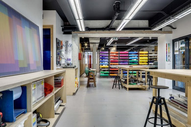 Réalisation d'un grand bureau atelier urbain avec un mur blanc, un sol en vinyl, aucune cheminée, un bureau intégré et un sol gris.