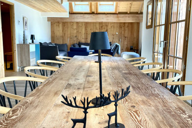 Inspiration pour une salle à manger ouverte sur le salon chalet en bois de taille moyenne avec un mur blanc, parquet clair, aucune cheminée, un sol beige, un plafond en bois et poutres apparentes.