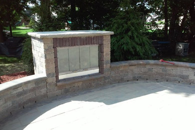 Example of a mid-sized classic backyard concrete paver patio design in Cleveland with a fire pit and no cover