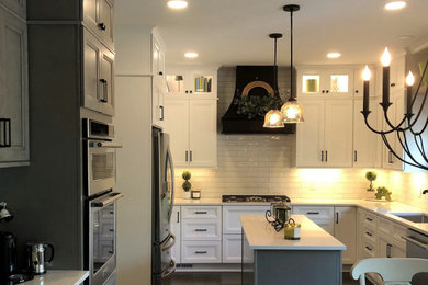 Example of a mid-sized transitional dark wood floor and brown floor eat-in kitchen design in Other with an undermount sink, flat-panel cabinets, white cabinets, quartz countertops, white backsplash, porcelain backsplash, stainless steel appliances, an island and white countertops