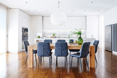 This is an example of a contemporary kitchen/dining combo in Melbourne with white walls, dark hardwood floors and brown floor.
