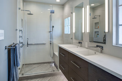 Inspiration for a mid-sized modern master gray tile and porcelain tile porcelain tile, gray floor and double-sink alcove shower remodel in San Francisco with an integrated sink, flat-panel cabinets, dark wood cabinets, solid surface countertops, a wall-mount toilet, gray walls, a hinged shower door, white countertops, a niche and a floating vanity