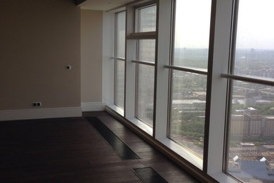На фото: открытая гостиная комната в стиле модернизм с деревянным полом и коричневым полом с