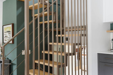 Diseño de escalera en U contemporánea de tamaño medio con escalones de metal, contrahuellas de madera y barandilla de metal