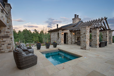 Example of a huge mountain style backyard tile patio design in Denver with a fire pit and a pergola