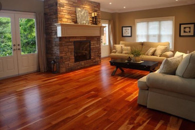 Example of a large classic light wood floor family room design in Montreal with beige walls, a standard fireplace and a stone fireplace
