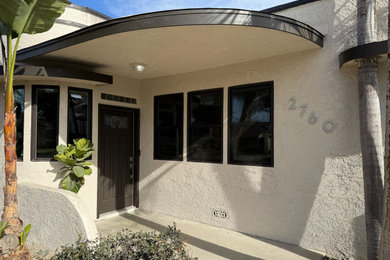 Inspiration for a mid-sized 1960s beige one-story stucco exterior home remodel in Los Angeles with a shingle roof and a white roof