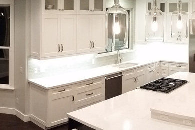 Eat-in kitchen - large contemporary u-shaped dark wood floor eat-in kitchen idea in Salt Lake City with white cabinets, subway tile backsplash, stainless steel appliances, an island, a drop-in sink, flat-panel cabinets, solid surface countertops and white backsplash
