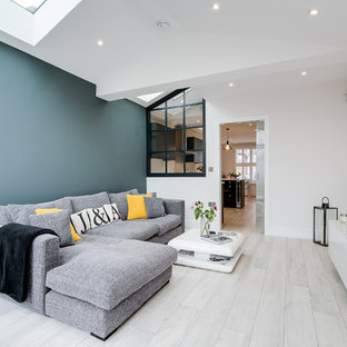 Inspiration för ett funkis vardagsrum, med vita väggar, målat trägolv, en väggmonterad TV och vitt golv