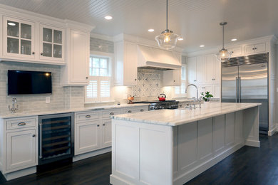Mid-sized transitional l-shaped eat-in kitchen in Boston with a farmhouse sink, shaker cabinets, white cabinets, marble benchtops, grey splashback, ceramic splashback, stainless steel appliances, dark hardwood floors, with island and brown floor.