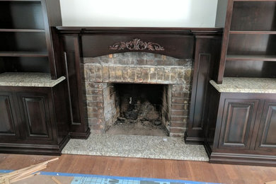 Elegant family room photo in New York with a standard fireplace and a wood fireplace surround