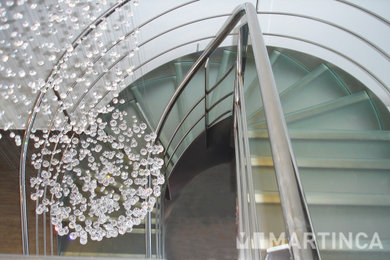 Imagen de escalera de caracol moderna con escalones de vidrio y barandilla de metal