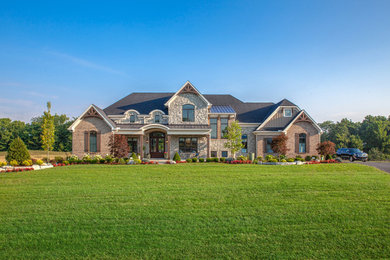Large country beige two-story mixed siding exterior home idea in Cincinnati with a mixed material roof