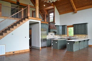 This is an example of a mid-sized arts and crafts u-shaped kitchen in Other with a farmhouse sink, raised-panel cabinets, green cabinets, marble benchtops, grey splashback, subway tile splashback, stainless steel appliances, dark hardwood floors, with island, brown floor and white benchtop.