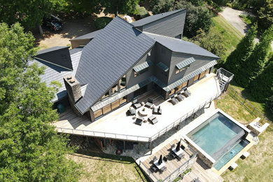 Elegant two-story house exterior photo in Other with a metal roof and a gray roof