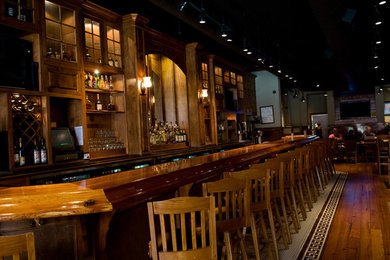 Example of an urban light wood floor seated home bar design in Atlanta with wood countertops
