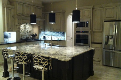 Large trendy l-shaped porcelain tile eat-in kitchen photo in Houston with a double-bowl sink, gray cabinets, granite countertops, stainless steel appliances, an island, blue backsplash, subway tile backsplash and raised-panel cabinets