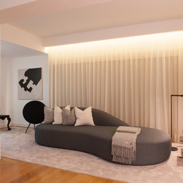 Paço de Arcos living room with curved sofa and fireplace wall