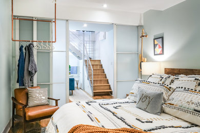 Bedroom - mid-sized rustic master light wood floor bedroom idea in New York with blue walls and no fireplace