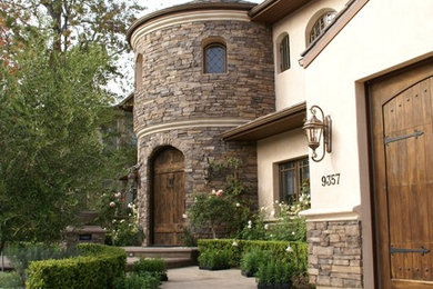 Large mediterranean beige two-story mixed siding house exterior idea in Los Angeles with a hip roof and a tile roof