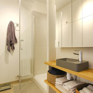 Ispirazione per una piccola stanza da bagno minimalista con ante a filo, piastrelle bianche, piastrelle in ceramica, pareti bianche, pavimento in cemento, top in legno e pavimento beige