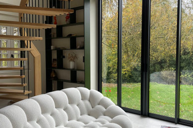Inspiration pour un salon mansardé ou avec mezzanine design de taille moyenne avec une bibliothèque ou un coin lecture, un mur beige, un sol en carrelage de céramique, un poêle à bois et un plafond cathédrale.