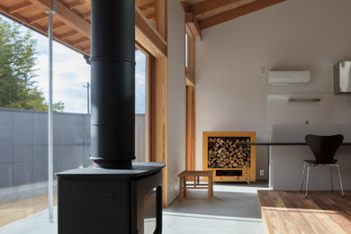 福岡にある小さな北欧スタイルのおしゃれなLDK (白い壁、無垢フローリング、薪ストーブ、コンクリートの暖炉まわり、表し梁) の写真