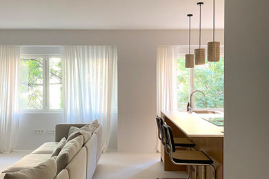 Foto de salón abierto minimalista de tamaño medio con paredes beige, suelo de cemento y suelo beige