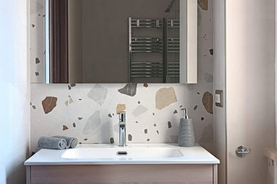 Immagine di una stretta e lunga stanza da bagno con doccia minimal di medie dimensioni con ante lisce, ante in legno chiaro, WC a due pezzi, piastrelle in gres porcellanato, pareti beige, lavabo da incasso, top in superficie solida, porta doccia scorrevole, top bianco, un lavabo, mobile bagno sospeso, pavimento in gres porcellanato e pavimento blu