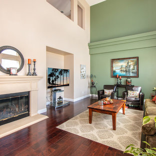 Small mediterranean enclosed living room in Dallas with green walls, dark hardwood flooring, a standard fireplace and a freestanding tv.