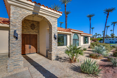 Example of a mid-sized tuscan beige one-story mixed siding house exterior design in Other with a hip roof and a tile roof