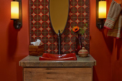 Powder room - small rustic multicolored tile and ceramic tile ceramic tile powder room idea in Los Angeles with a vessel sink, furniture-like cabinets, medium tone wood cabinets, quartzite countertops and red walls