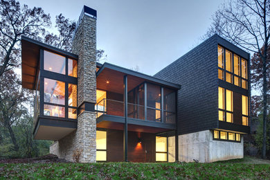 Photo of a large modern two-storey black house exterior in Milwaukee with a flat roof and mixed siding.
