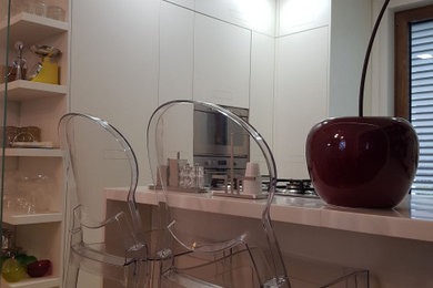 Ispirazione per una piccola cucina moderna con ante lisce, ante bianche, top in superficie solida, paraspruzzi bianco e top bianco