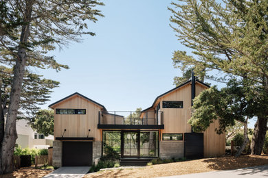 Example of a mid-sized trendy beige two-story wood house exterior design in Other with a metal roof and a black roof