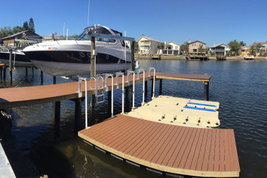 Dock - small tropical backyard dock idea in Tampa with no cover
