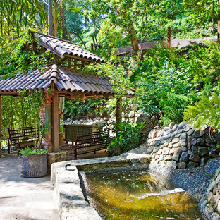 Design ideas for an asian sloped garden in Los Angeles with a water feature.