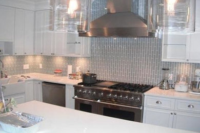 Inspiration for a l-shaped kitchen remodel in Miami with matchstick tile backsplash, stainless steel appliances, an island, beaded inset cabinets, white cabinets and solid surface countertops