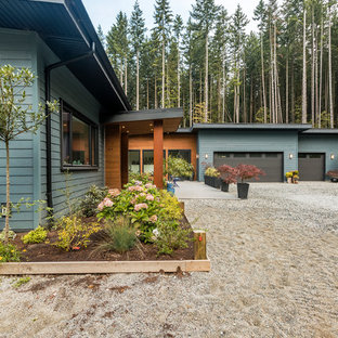 バンクーバーのモダンスタイルのおしゃれな家の外観 (コンクリート繊維板サイディング、青い外壁、片流れ屋根、戸建、金属屋根) の写真