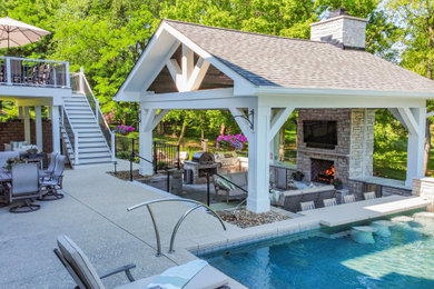 Example of a huge cottage chic backyard concrete paver patio design in St Louis with a fireplace and a gazebo