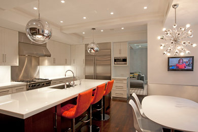 Inspiration for a large transitional l-shaped dark wood floor eat-in kitchen remodel in New York with an undermount sink, flat-panel cabinets, white cabinets, quartz countertops, white backsplash, stainless steel appliances and an island