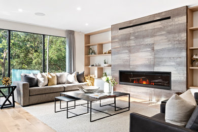 Inspiration for a contemporary open concept living room in Sydney with white walls, light hardwood floors, a ribbon fireplace, a tile fireplace surround and beige floor.