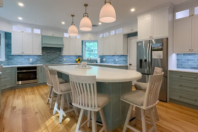 Open concept kitchen - huge transitional light wood floor and beige floor open concept kitchen idea in Bridgeport with an undermount sink, shaker cabinets, blue cabinets, quartz countertops, blue backsplash, ceramic backsplash, stainless steel appliances, an island and white countertops
