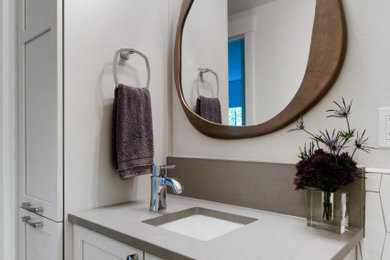 Example of a small transitional 3/4 white tile and ceramic tile porcelain tile, gray floor, single-sink and wainscoting alcove shower design in Seattle with recessed-panel cabinets, gray cabinets, a one-piece toilet, white walls, an undermount sink, quartz countertops, a hinged shower door, gray countertops and a built-in vanity