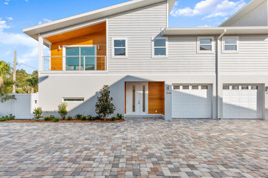 Inspiration for a mid-sized contemporary gray two-story mixed siding exterior home remodel in Tampa with a shingle roof