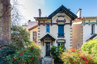 Réalisation d'une grande façade de maison multicolore tradition à deux étages et plus avec un revêtement mixte, un toit à deux pans et un toit en tuile.