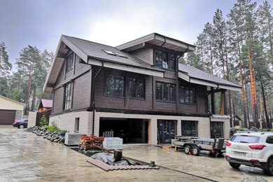На фото: большой, двухэтажный, деревянный частный загородный дом в скандинавском стиле с крышей из гибкой черепицы