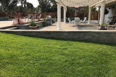 Inspiration for a mid-sized timeless backyard stone patio kitchen remodel in San Francisco with a pergola