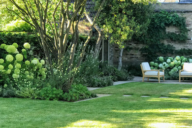 Design ideas for a medium sized contemporary back formal partial sun garden for summer in Surrey with natural stone paving.