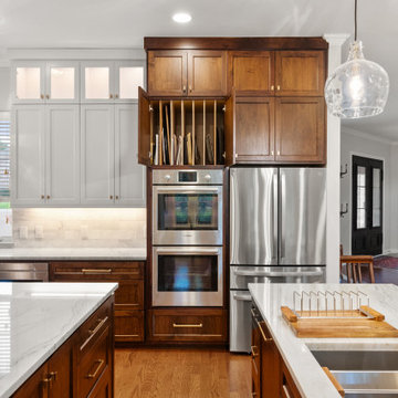 Symmetrical white and wood two-tone kitchen with double ovens and storage